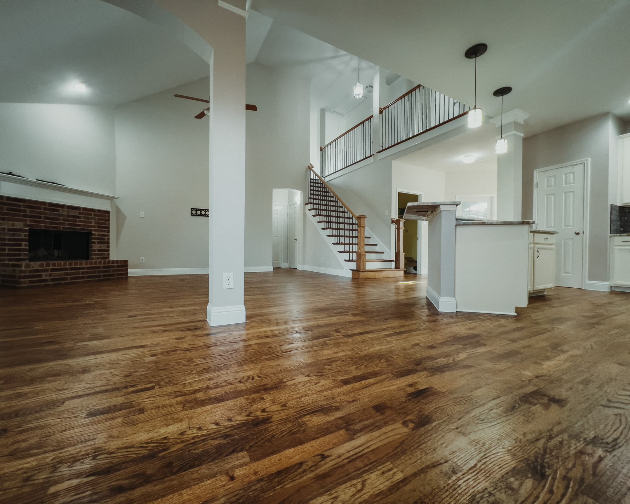 Great room with hardwood floors, brick fireplace and staircase — Rise Reno