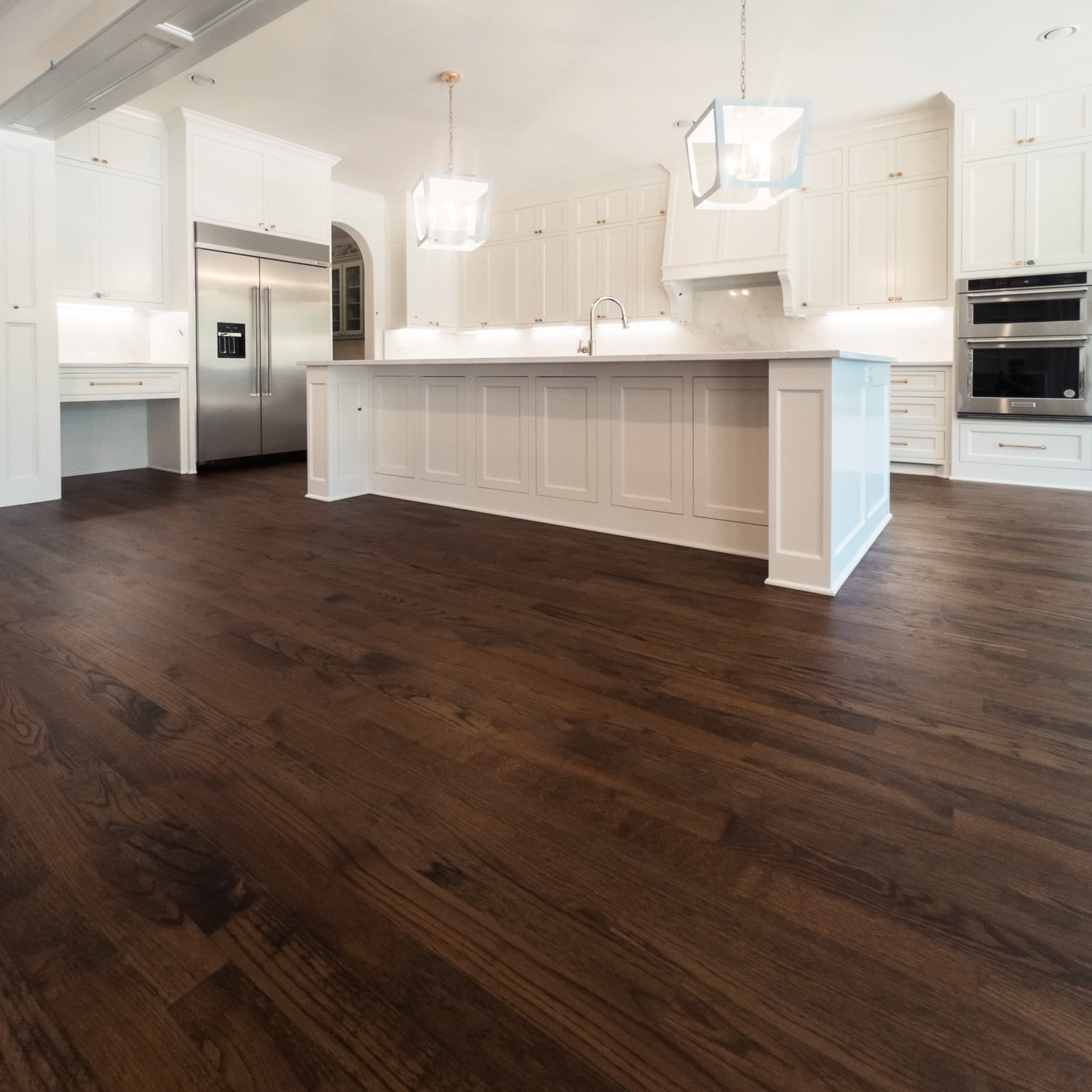 White kitchen with dark stained hardwood and large island — Rise Reno