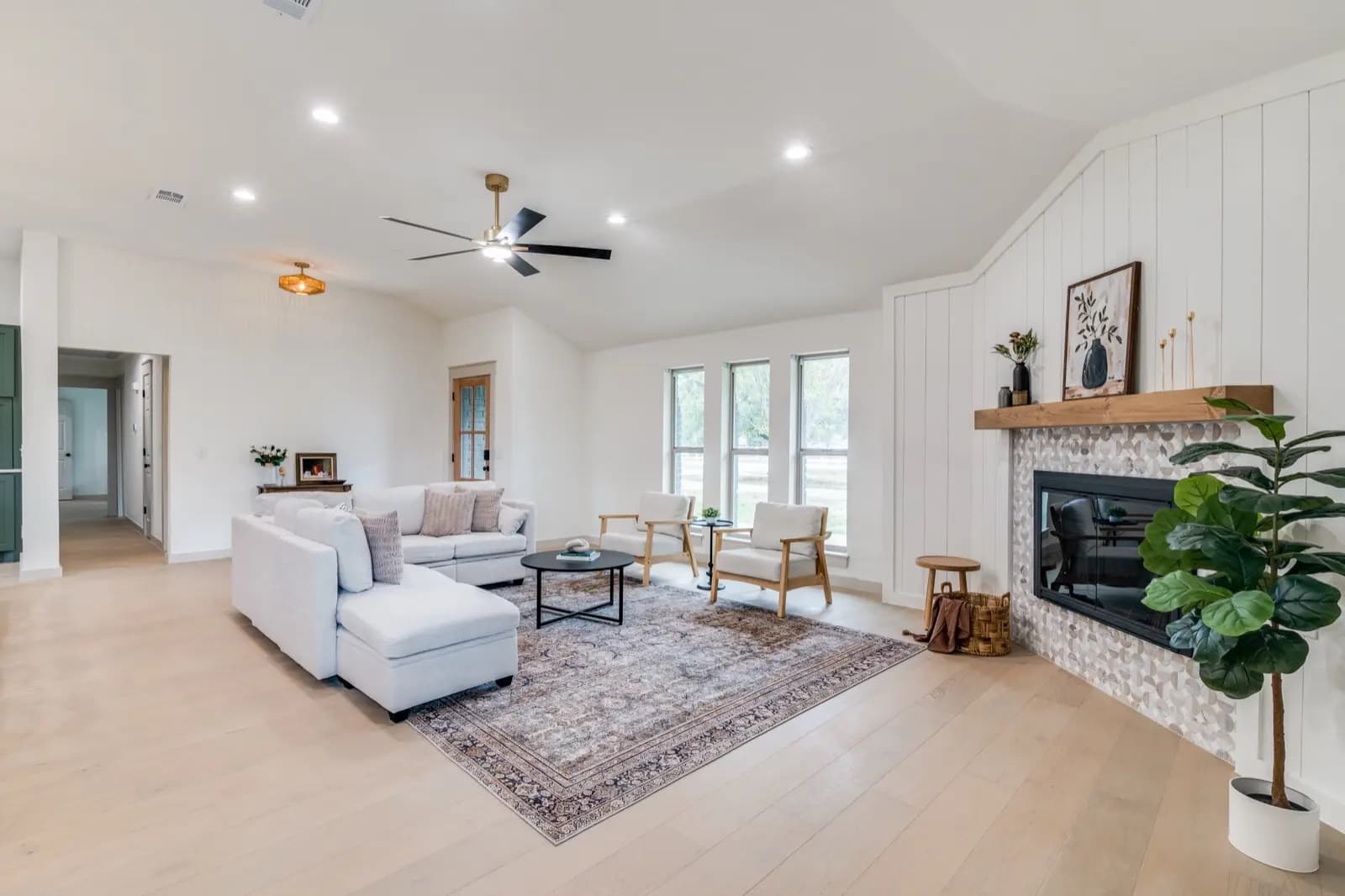 Living room with light wide-plank flooring and shiplap fireplace — Rise Reno